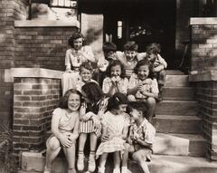 A bunch of kids sitting on a front stoop.