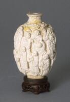 A porcelain snuff bottle with images of luohan (Buddhist sages, arhats) carved in high relief.