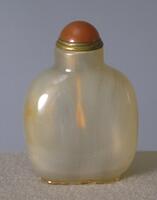 An square agate snuff bottle with rounded edges. On top of the bottle is red glass snuff bottle set in a brass collar.