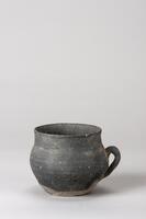 It has a flat base, globular body and straight neck with an everted rim. The color is dark grayish-blue.<br />
<br />
This is a blue-gray, high-fired stoneware cup with a handle. The mouth of the cup is slightly splayed and has a narrow, rounded rim. The body is widest at its center where a semicircular handle is attached vertically. The inner and outer surfaces show faint traces of rotation and water smoothing. The base is wide and flat and has no foot.
<p>[Korean Collection, University of Michigan Museum of Art (2017) p. 70]</p>
