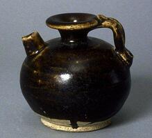 A globular stoneware ewer with a wide foot and narrow trumpeted neck with direct rim. It has a short straight spout placed high upon the shoulder, and coiled handle with articulation extending from the mouth to the shoulder. It is covered in a dark brown glaze stopping high above the foot.