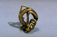 Pendant in the form of a human figure in a circular shape.