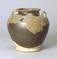 A buff stoneware globular jar, with a tapered base and wide, high shoulders, tapering to a wide, short neck with an everted rime and two small loop Hades on the sides near the rim. The work ranges from shades of brown to tan.