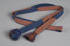 Blue and orange in a woven pattern, fringe of the same colors on both ends.