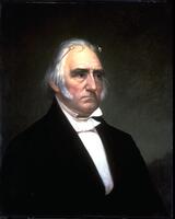 Portrait of white-haired man wearing black jacket and white cravat with glasses on forehead. Black/dark colored backdrop. (Larson 2/5/18)