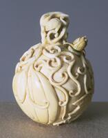 A spherical ivory snuff bottle with high relief vines and leaves surrounding the outside. The stopper is also covered with vines and leaves.