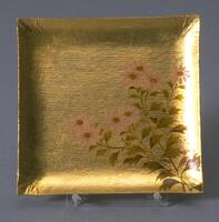 Autumn flowers are painted in colored lacquer on plates of gold leaf. The quiet, natural plant motifs stand out against the glittering square of gold.