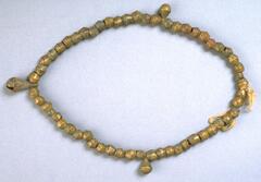 Belt with brass beads and three crotal bell pendants. 