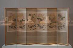A six panel folding screen depicting pairs of carp on each of the lower portions of each panel, and lotus blossoms.