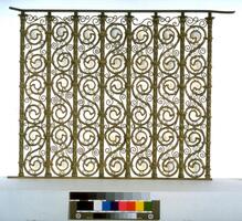 Gilt metal balustrade fragment from staircase in Havemeyer house. Vertical rods alternate with S-shaped metal design with milky opalescent &quot;commas&quot; in the &quot;S&quot;. These alternating elements are held together with soft metal joins; the glass pieces are set loosely in their metal mounts.
