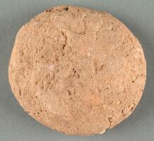 A disk of coarse refractory ceramic clay.