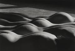 This image shows four nude figures lying prone, their forms repeating in a diagonal across the frame.