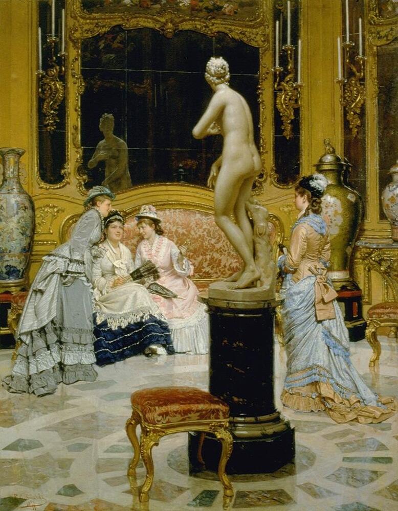 Two women on a settee dressed in elegant 19th century attire, one holding a fan and the other a parasol, while another richly clad woman leans in close beside them, in a lavishly decorated interior setting with ornately carved gilded walls, a large mirror above the settee, inlaid marble floor, and large vases to either side of the settee. In the center of the room is a sculpture of the Medici Venus on a pedestal with her back to the viewer, her reflection evident in the mirror. Between the base of the sculpture and the viewer is an elaborately carved gilt stool covered with rich red fabric. Beside the sculpture, another woman holding a book walks towards the cluster of women.