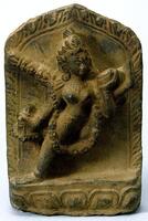 A small stone sculpture in bas-relief, depicting a tantric goddess. The back of the image is carved in a stylized petal shape, while the figure is crudely carved in relief on the front.