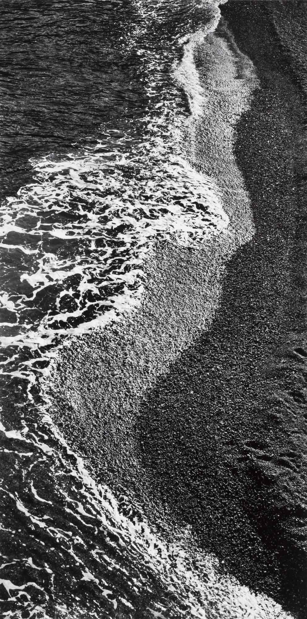 Black and white photograph of waves crashing on a beach.&nbsp;