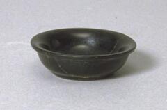 A small black glass bowl with a flared rim.