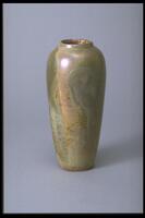 This tall, slender vase has a narrow mouth and a mottled iridescent glaze in tans, peach, and green. Throughout there is a pronounced crackle pattern in the glaze.