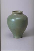 Ceramic vessel with short neck, rounded shoulder, flared lip and wide mouth covered in iridescent gray-green glaze