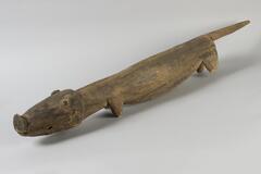Carved pig with round nose, pointed tail and long midsection.