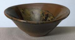 Teabowl with brown/black tenmoku glaze and golden leaf design on interior.