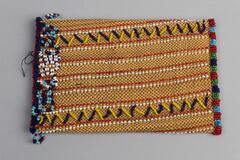 Beaded and woven pouch in brown woven base with two blue and yellow chevron design and red and white stripes. Multicolored beaded bottom with looped beaded fringe at opening in blue, red, lighter blue and white. Back of pouch has red and white stripes.