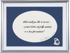 The phrase "Which would you like to eat now - a peanut butter and jelly sandwich, or a tuna fish sandwich?" is digitally printed on paper and signed by artist then placed in a mass produced frame with a flower sticker in the lower right corner. 