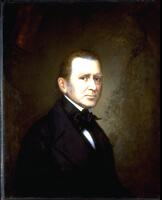 Portrait of man in black suit with black cravat against a dark backdrop. ( Larson 2/5/18)