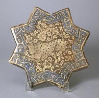 This Il-Khanid period molded 8-pointed star tile contains a central spotted feline together with Arabic inscriptions on the outer rim. 