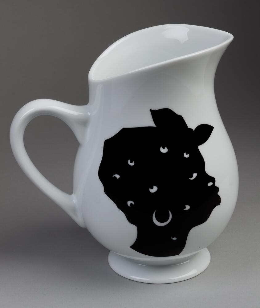 White glazed porcelain pitcher with two different black silhouette faces in profile, one on each side.