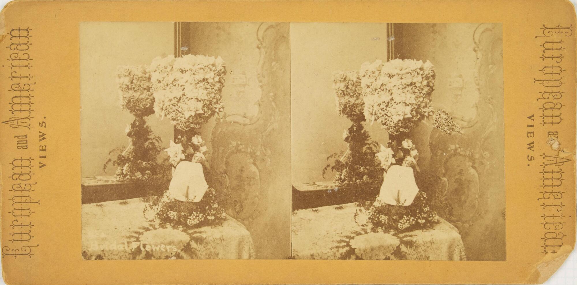 This black and white stereoscopic image features two images of a bundle of flowers that have a shapped top and flower base. It is on a table with a mirror behind it on the left. Sepia toned.