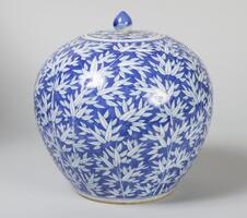 A blue bulbous jar with a white bamboo motif and lid.