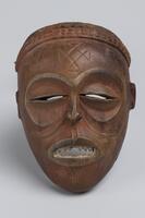 Oval-shaped face mask&nbsp;with slit eye-openings, a mouth with articulated teeth, and scarification on the forehead.&nbsp;
