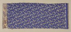 A piece of fabric with butterflies on a dark blue background. One both ends, there is brown fabric.