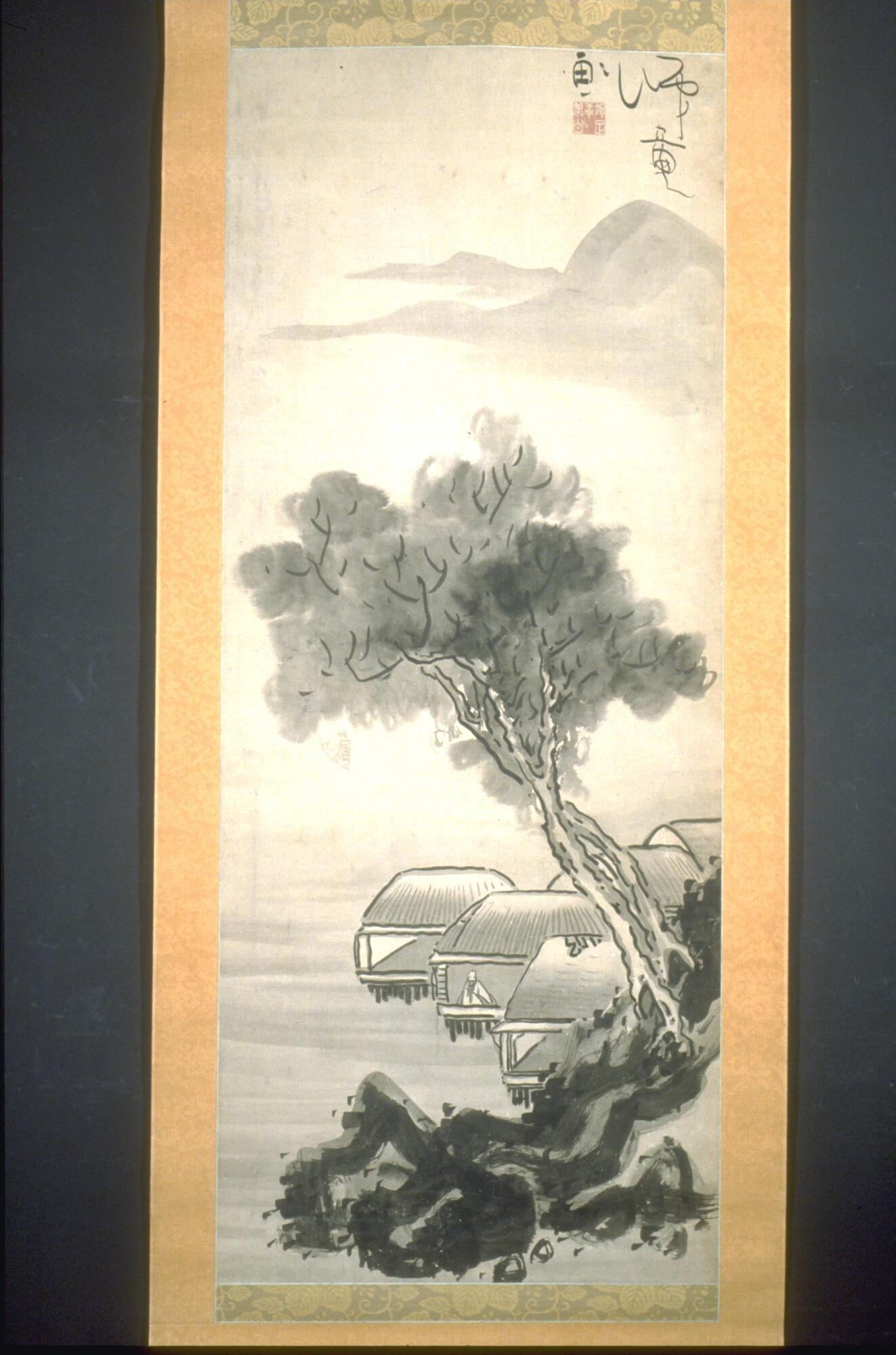 This hanging scroll depicts a scholar seated in a pavillion built into a mountainous landscape overlooking a bay. In the foreground, dark rocks rise up from the water to the right, while two large trees extend out over the water. Behind this is a series of five structures with a single figure inside, gazing out over the water. In the background, mist and mountains are suggested through the use of a lighter gray ink wash. 