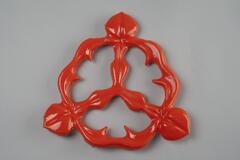 Orange in color and floral in shape. Is attached to the larger base pieces when installed.