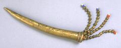 Brass horn with a pointed tip and a cork stopper decorated with four strands of brass and multi-colored beads. 