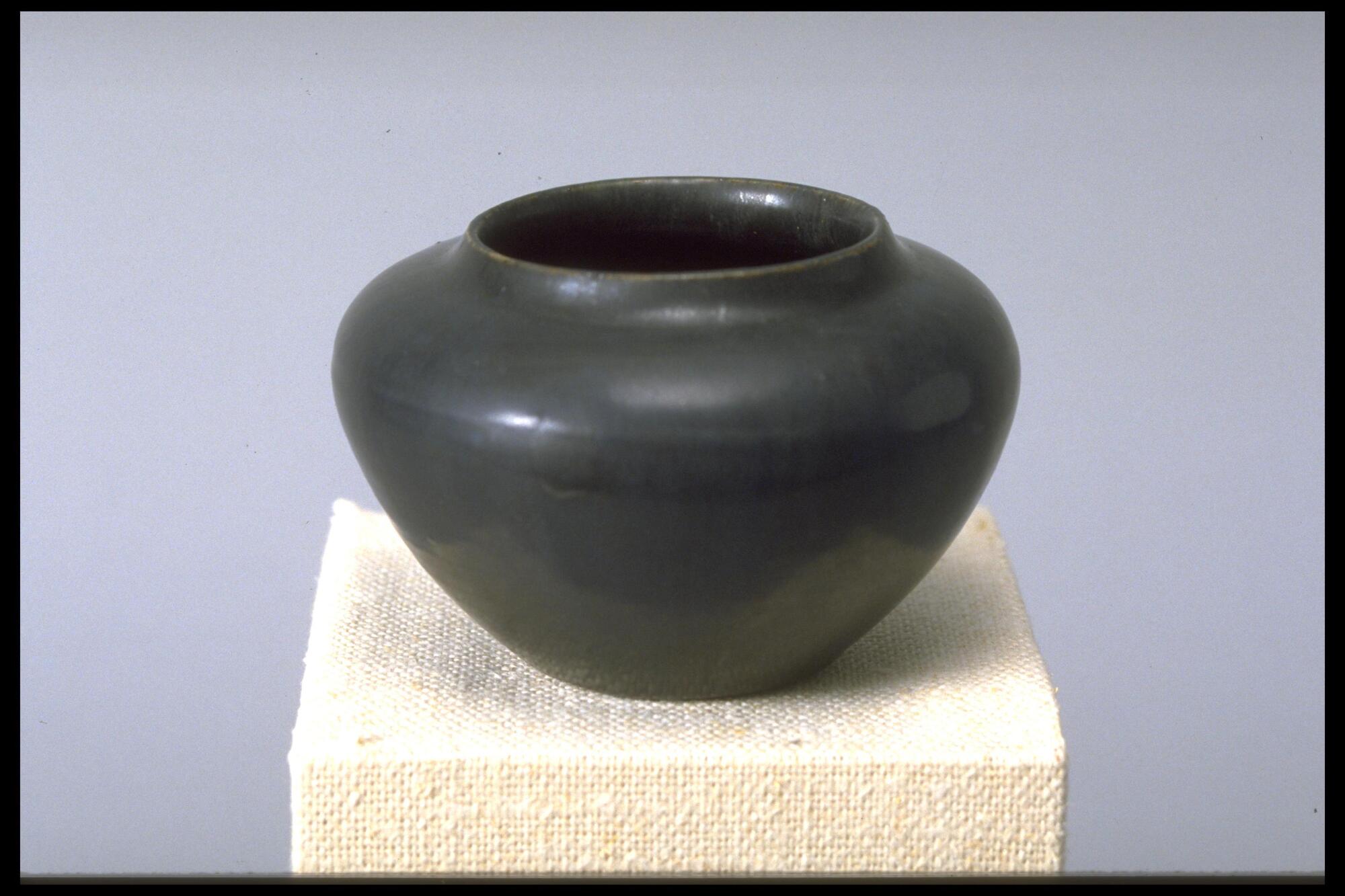 Ceramic vessel with wide mouth and rounded shoulder covered in a dark blue-gray mat glaze