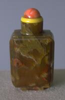 A rectangular&nbsp;agate snuff bottle. On the top is a yellow glass collar and coral bead stopper.