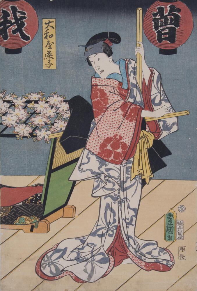 In this print, a woman wields a large cross-shaped pole, looking over her right shoulder.  To her left, a litter rests on the dock with a canopy of cherry blossoms.  Above her are two red paper lanterns; the one on the right has the character “<em>s</em><em>ō</em>”; the lantern on the left has the character “<em>ware</em>”.<br /><br />
This is the right panel of a triptych.<br /><br />
Inscription: Hanmoto, Izutsuya (Publisher's seal); Tori [Rooster] 4 aratame (Censor's seals); Yamatoya Enshi<br />
 