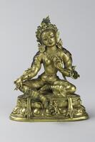 A suberply cast hollow bronze figure of Tara, a Buddhist goddess, shown leated in the lalitasana pose ("royal ease," with one knee bent and the other relaxed), her right hand extended to her right knee in vara mudra (the gesture of charity), and her left hand in vitarka mudra (the gesture of teaching, with the thumb and third finger brought together). She wears a dhoti and jewelry, including an elaborate tiara and enormous lotus-petal design ear plugs. Her face has a broad, open forehead, with wide, slightly arching brows; her eyes are downcast with "s"-shaped upper lids; her nose is straight and long, and her mouth, in a curved Cupid's bow shape, is small but full. Her torso leans slightly to her left, which is balanced by the right tilt of her head. She sits on a double lotus dais with beaded upper and lower rims. The image and the base were case in one piece in the lost-wax method.  There are traces of red paint for her mouth and blue paint for her hair.