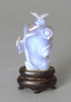 A chalcedony snuff bottle with carved decorations of flowers and butterflies in raised relief.