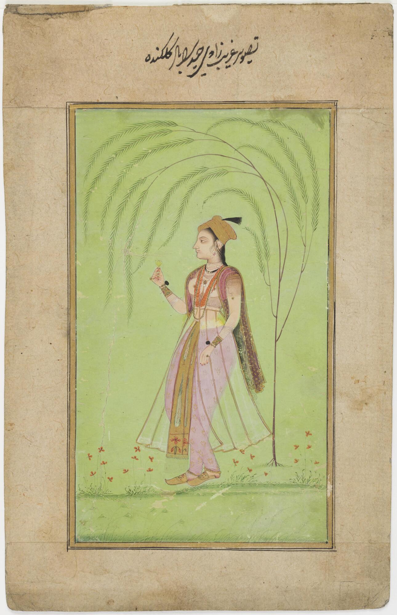 The lady stands against a bright green background with only a hint of physical setting. There are some ground lines at her feet with springs of red flowers and a simple stylized willow tree that curves around the figure. She stands with her body turning towards her right with her head in profile. She lifts a flower up in her right hand and hangs her left arms down past her waste. She wears tight lavender colored trousers with a diaphanous skirt covering them with a gold and colored brocaded scarf hanging down the center. Her breasts appear bare, but actually the blouse is also sheer, with a darker color at the shoulders and below her breasts. She wears gold brocade slippers and wide bracelets with black pompoms and rings, necklaces, earrings and a scarf hangs from her shoulders. A gold turban with a black aigrette crowns her. The portrait is framed with some gold and black lines and placed on a simple, buff colored border. An inscription in nastaliq&lsquo; script is above the painting.
