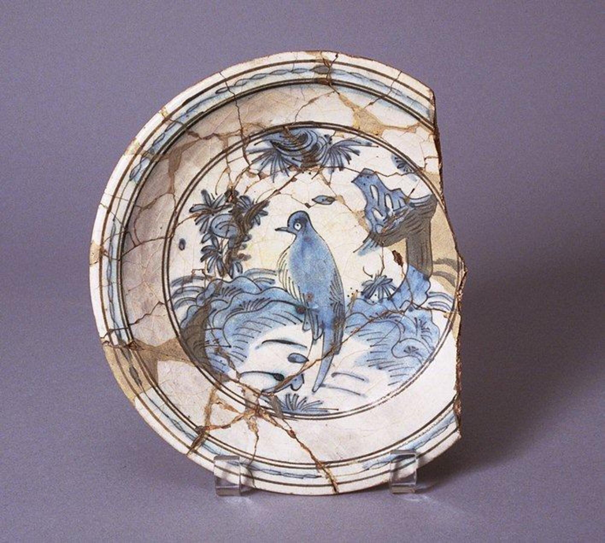 A plate with missing side. It has depictions in blue.