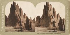 This color stereoscopic image features two images of a large vertical rock formation with pointed tops.