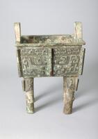 square ding (ting) tripod with four legs, the body as well as the upper portion of the four legs is decorated with "t'ao-t'ieh" zoomorphic design. One of the leg was recast after the rest of the body has been completed, thus had a less refined craftmanship and joint line at its base. The double loop handles are also decorated with zoomorphic design. A group of three inscription is cast on the upper portion of the interior wall, which reads as Fu (father) Ji (day name), followed by an symbolic representation of a chariot, possibly a clan emblem. The interior is plain, the animal bone remains attached to the bottom and variations in patina patterns with a line running through the middle indicates that the vessel was once filled with cooked meat offerings, presumably in a Shang elite burial in late second millennium B.C.E.