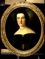 Woman with brown hair and a dark green dress, gold brooch on the center of her chest. Oval frame.