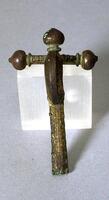 This fibula, a type of brooch used to pin outer garments, features a crossbar that ends in three onion-shaped terminals, which give the fibula a shape reminiscent of a crossbow. An arched bow connects the crossbar to the longer catchplate, which is ornamented with vegetal motifs.