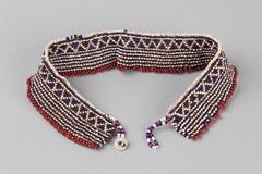 Beaded necklace with triangular and striped design. Button closure, red, blue and white beads.