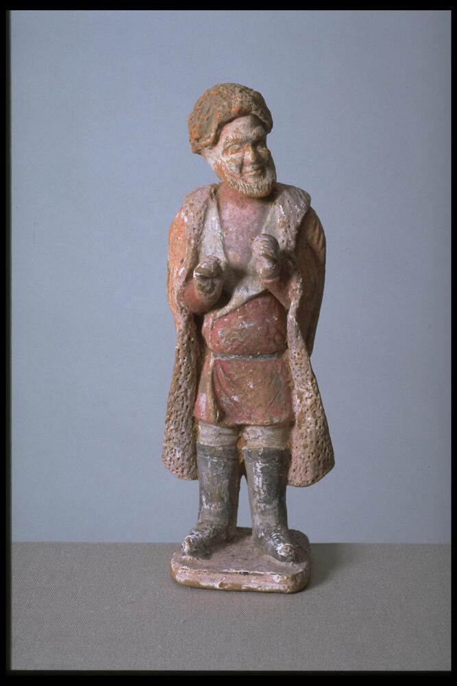 Standing male figure with bushy beard wearing a robe and black boots, decorated with red and black pigment.<br />