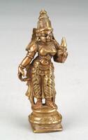 Shridevi stands in a tribhanga pose (with three bends) with her right arm hanging pendant to her side and holding a lotus bud in her left hand. She leans towards the figure of Vishnu in the grouping of three bronzes.   She stands on a base consisting of a flat square element topped with a series of five round rings.  She wears a decorated lower garment flared out on either side in a pattern.  She wears a decorated belt and necklaces, bracelets and armlets, with shoulder loops, earrings and a crown.  The jewelry and crown is highlighted with gold paint as is his clothing and the two attributes.  She also wears a band across her breasts, a characteristic of Shridevi in groupings with Vishnu and his other consort, Bhudevi.<br />